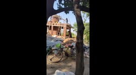 Man laughs off fall after failed pole descent at construction site in Farrukhabad, India