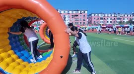 Student tumbles inside inflatable hamster wheel at school fair in Liaoning, China