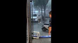 Woman loses balance in strong wind during rain in Shandong, China