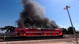 Firefighters extinguish a burning train car during a drill, timelapse
