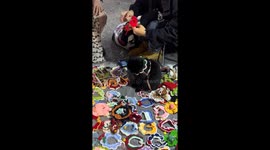 Cat models crochet hat at market stall in China