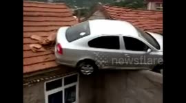 Car gets stuck on the roof of a house