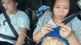 Woman ties Fisho Soy Sauce Flavor snack while man eats during drive in Liaoning, China