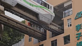 trains entering and exiting a building at liziba station in chongqing, china