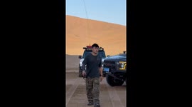 Man covered in dust after Ford F-150 speeds by in Shaanxi, China