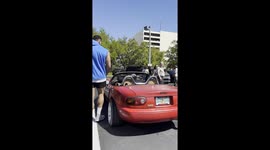 A 6’10” giant tries to fit into a tiny red Mazda convertible — even without a roof, it’s still a hilarious struggle.