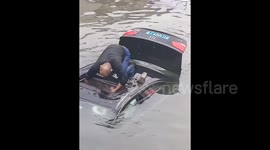 Car plunges into river to avoid cyclist, heroic passerby smashes sunroof to rescue trapped driver