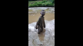 Children covered in mud after playing in Yunnan, China