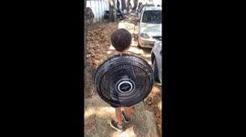 Boy carries school backpack made from an electric fan in Rio de Janeiro, Brazil