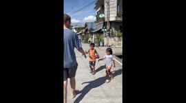 Local children greet tourist with respectful forehead blessing in the Philippines