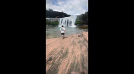 Man slips while posing at Tham Phra Waterfall in Bueng Kan, Thailand
