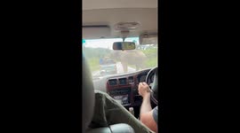 Angry wild elephant storms toward a car on mountain road in Thailand