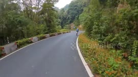 Cyclist loses balance on a sharp mountain curve in Zhejiang, China