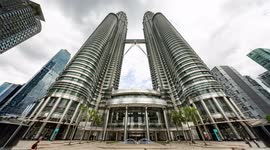 The petronas twin towers in kuala Lumpur during daytime with crowds of people on the streets below
