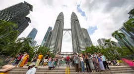 The petronas twin towers in kuala Lumpur during daytime with crowds of people on the streets below
