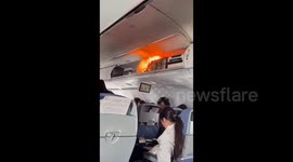Terrifying moment lithium battery catches fire in overhead storage and forces plane to make emergency landing in Shanghai