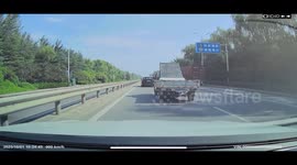 Driver narrowly avoids falling solar heater on highway in Shandong, China