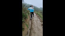 Man and child slip and tumble in muddy trail in Gansu, China