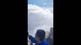 Hikers engulfed by clouds on the top of mountain trail