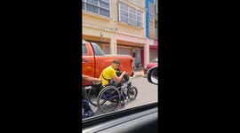 Wheelchair users cling to a friend riding automatic bike