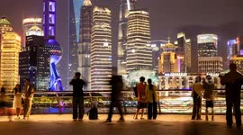 tourists on the bund in shanghai with the famous Pudong district’s futuristic skyline