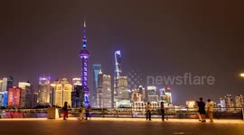 tourists on the bund in shanghai with the famous Pudong district’s futuristic skyline