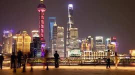 tourists on the bund in shanghai with the famous Pudong district’s futuristic skyline