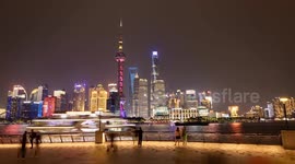 tourists on the bund in shanghai with the famous Pudong district’s futuristic skyline