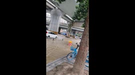 Road barriers float away on flooded road following a burst pipe