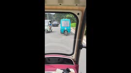 Vendor drives tuk tuk backwards on road in China