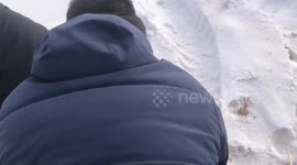 Two men enjoy playful tire sledding in heavy snow in Heilongjiang, China