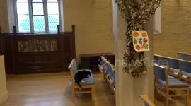 Pushkin the cat is washing face and paws at St Philips Church dressed for Harvest Festival 2025