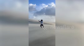 Visitor struggles against furious winds of Storm Benjamin on France’s Dune du Pilat