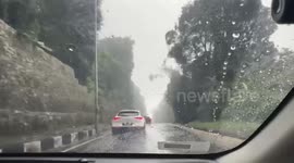 Cars narrowly avoid rocks as heavy rain triggers landslide in Malaysia