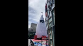 Giant Christmas tree wrapped in white sheet for two-in-one Halloween decoration