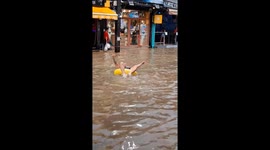 Tourist splashes around in rubber ring as street floods in Thailand
