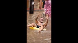 Tourist splashes around in rubber ring as street floods in Thailand