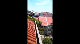 Repairman stumbles on roof as he carries air conditioning unit on shoulder