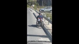 Dog helps push a man in a wheelchair in Sichuan, China