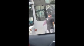 Angry motorcycle rider hits bus window with helmet in road rage attack