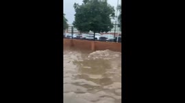Bus struggles through deep floodwaters at Plaza de la Diversión in Seville, Spain