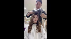 Barber's toupee comes loose as he styles woman's hair