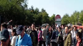 Massive crowds gathered at a bus stop waiting to visit Fragrant Hills Park in Beijing