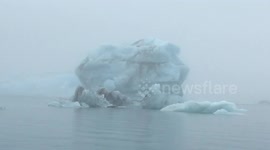 Iceberg flips over in front of tourist boat in Iceland