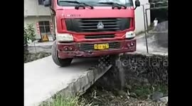Lorry tries to cross narrow bridge, nearly falls off