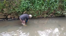 Unique the old man looked for worms in the shallow river.