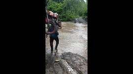 Man Carries His Motorcycle Across River