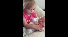Toddler sings song to her newborn sister