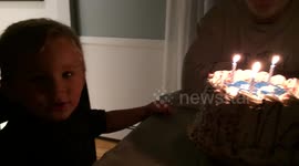 Toddler tries to blow birthday candle in hilarious manner