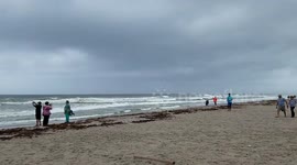 People gather on Florida beach to film and photograph approaching hurricane